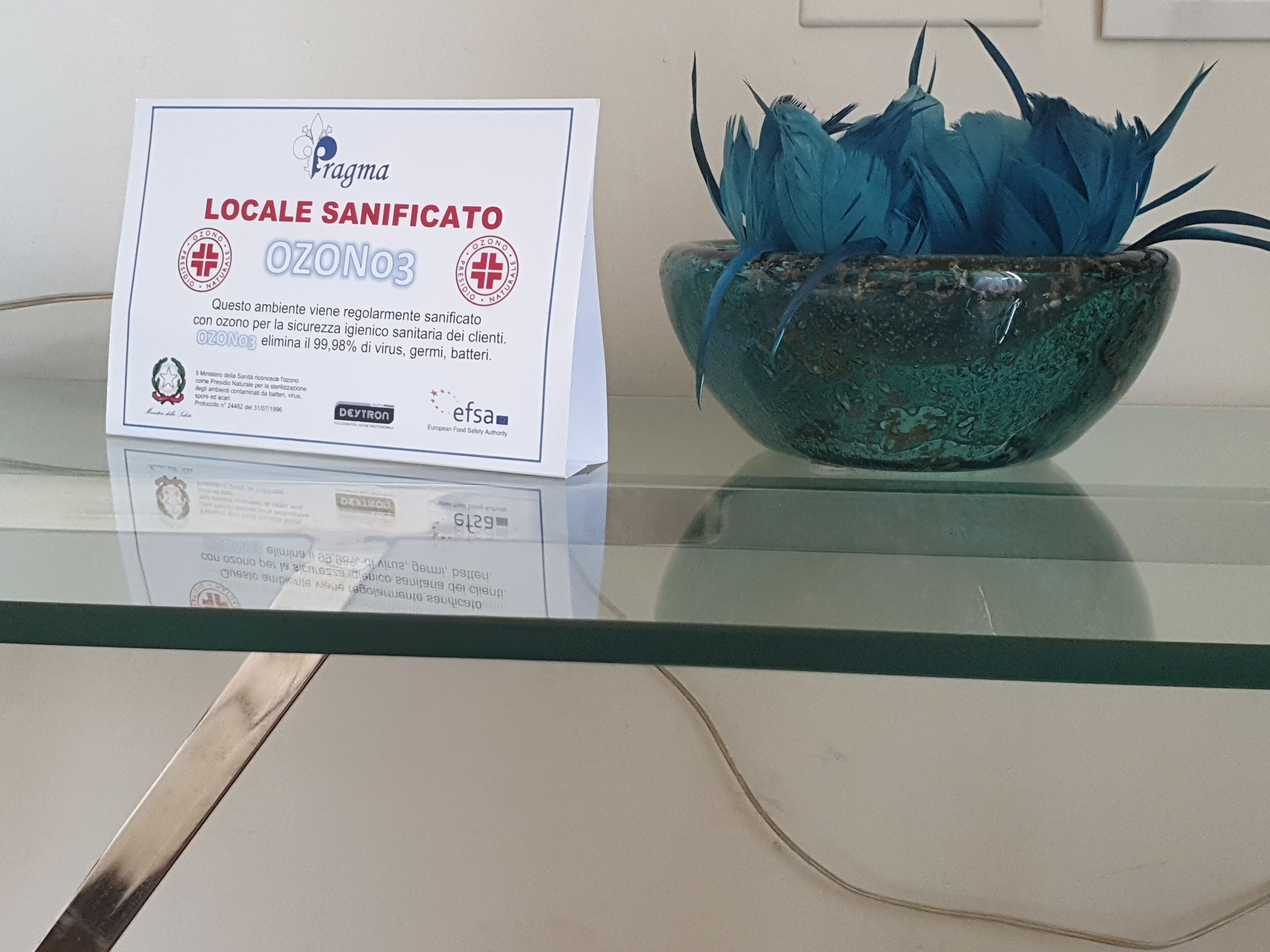 A glass table with a certificate and a decorative bowl.