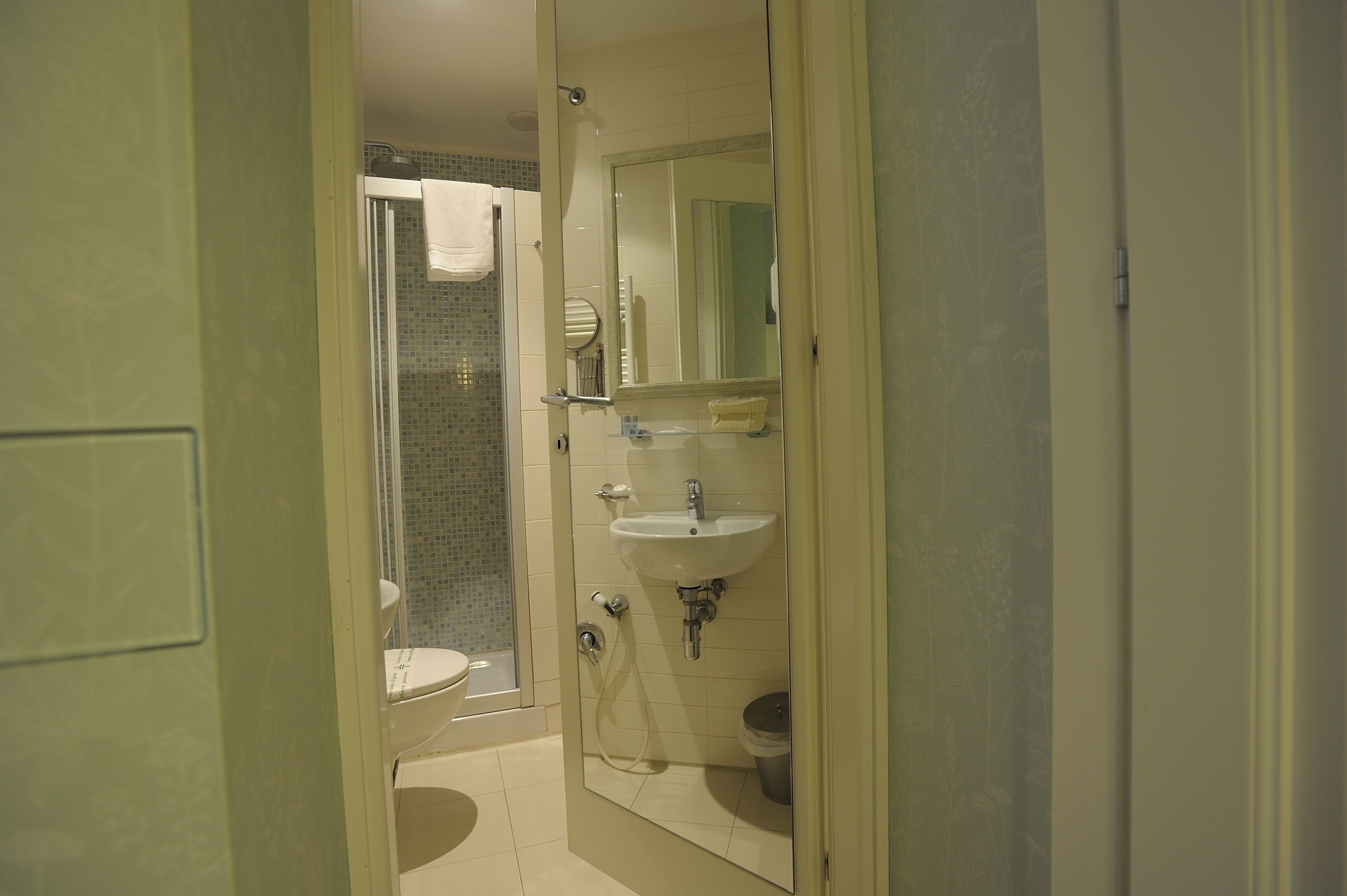 Een badkamer met toilet, wastafel en douche.
