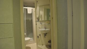 Een badkamer met toilet, wastafel en douche.