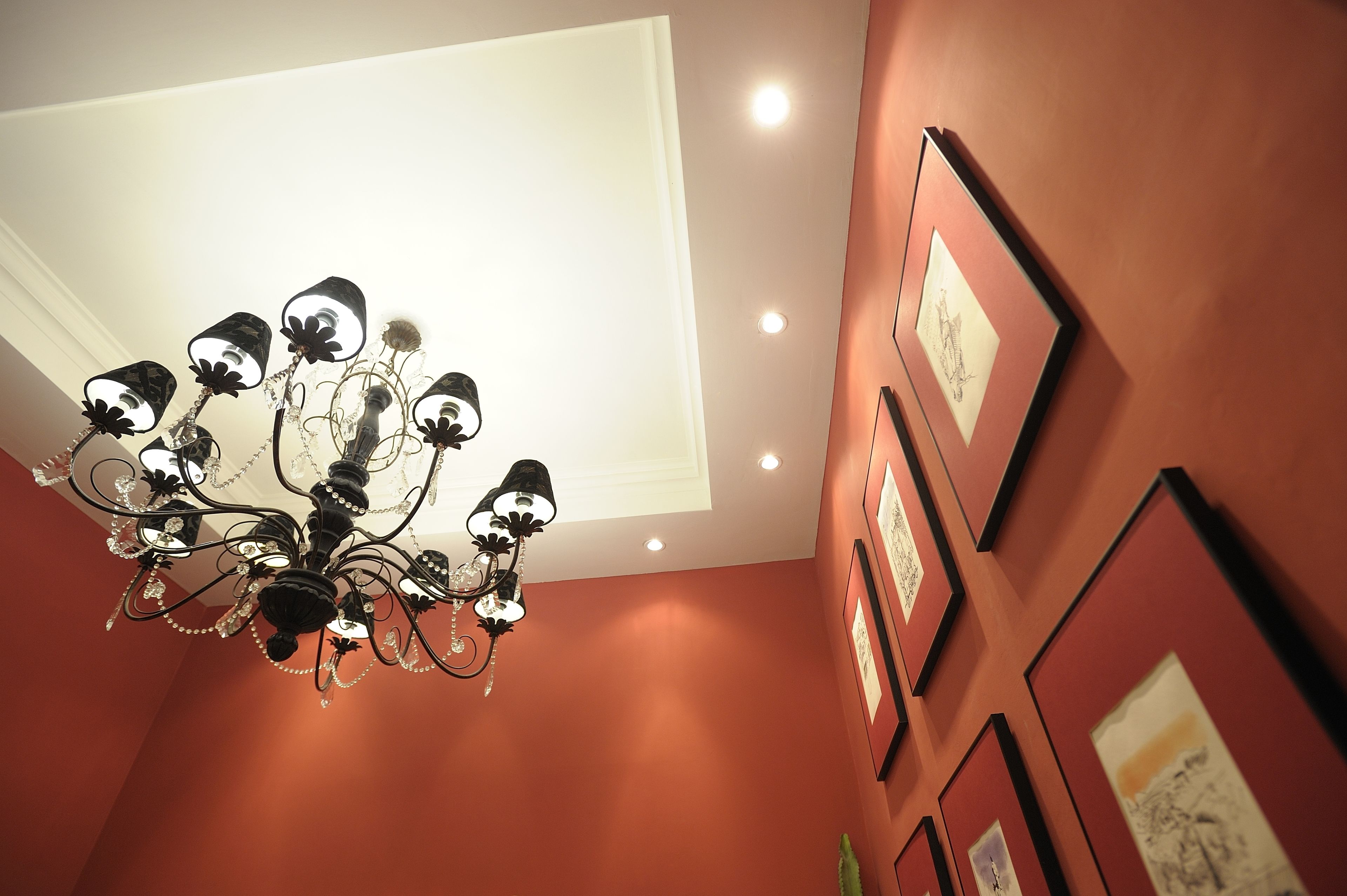 A chandelier with multiple lights and a ceiling with recessed lighting.