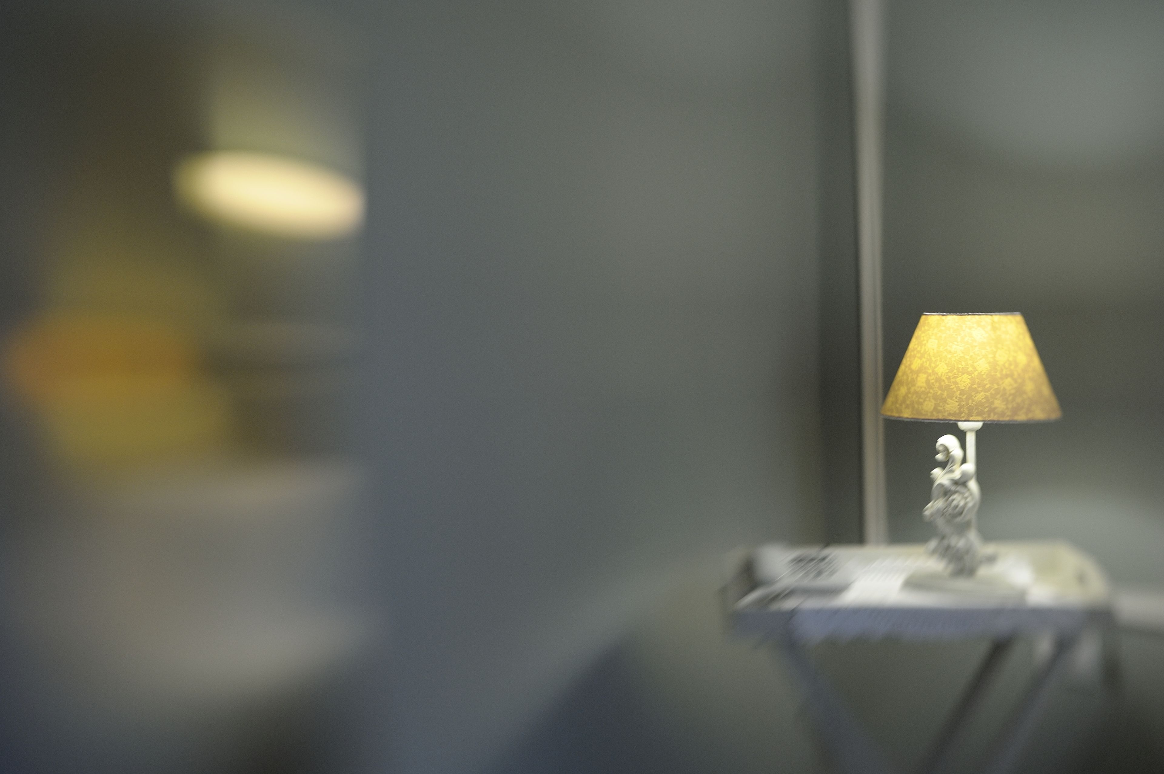 En lampe med en struktureret skærm på et lille bord.