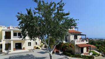 Un edificio de dos pisos con un balcón y vista al mar.