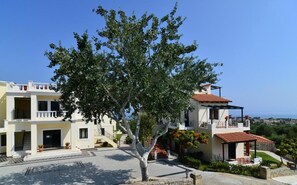 A two-story building with a balcony and a view of the sea. - Antilia Apts (Platanias)