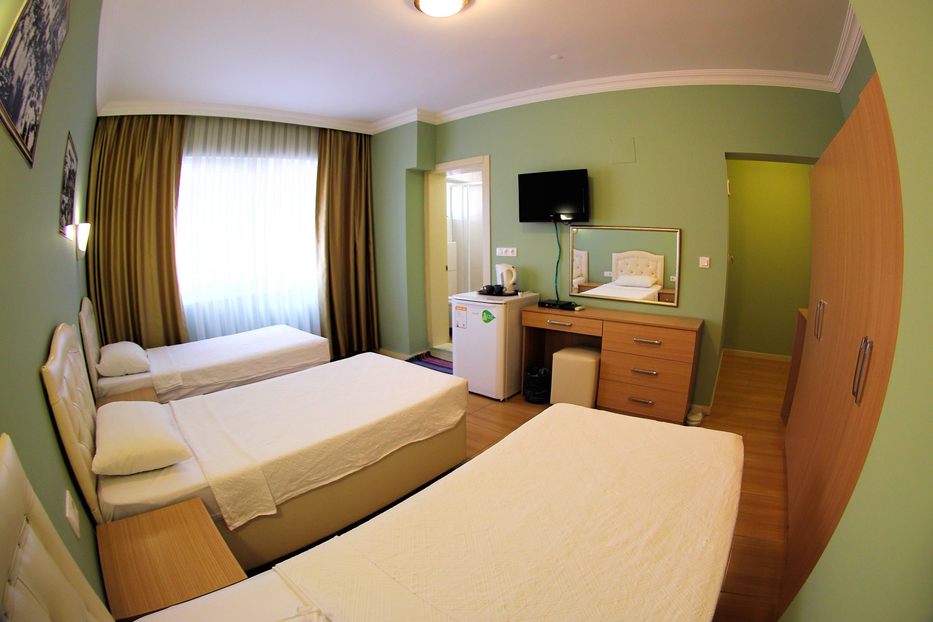 A hotel room with two beds, a desk, a television, and a wardrobe.