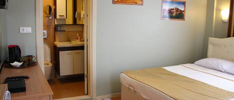 Un dormitorio con cama, escritorio, lavamanos y espejo.