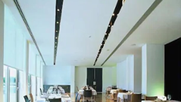 A spacious dining area with tables set for meals, large windows, and a modern interior design. - Hotel Duomo (Benifayo)