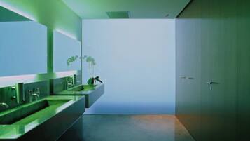 Een moderne badkamer met een grote spiegel, een wastafel en een toilet.