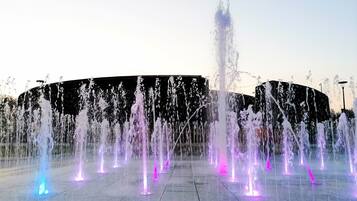 A water fountain display with multiple jets of water, illuminated by colorful lights.