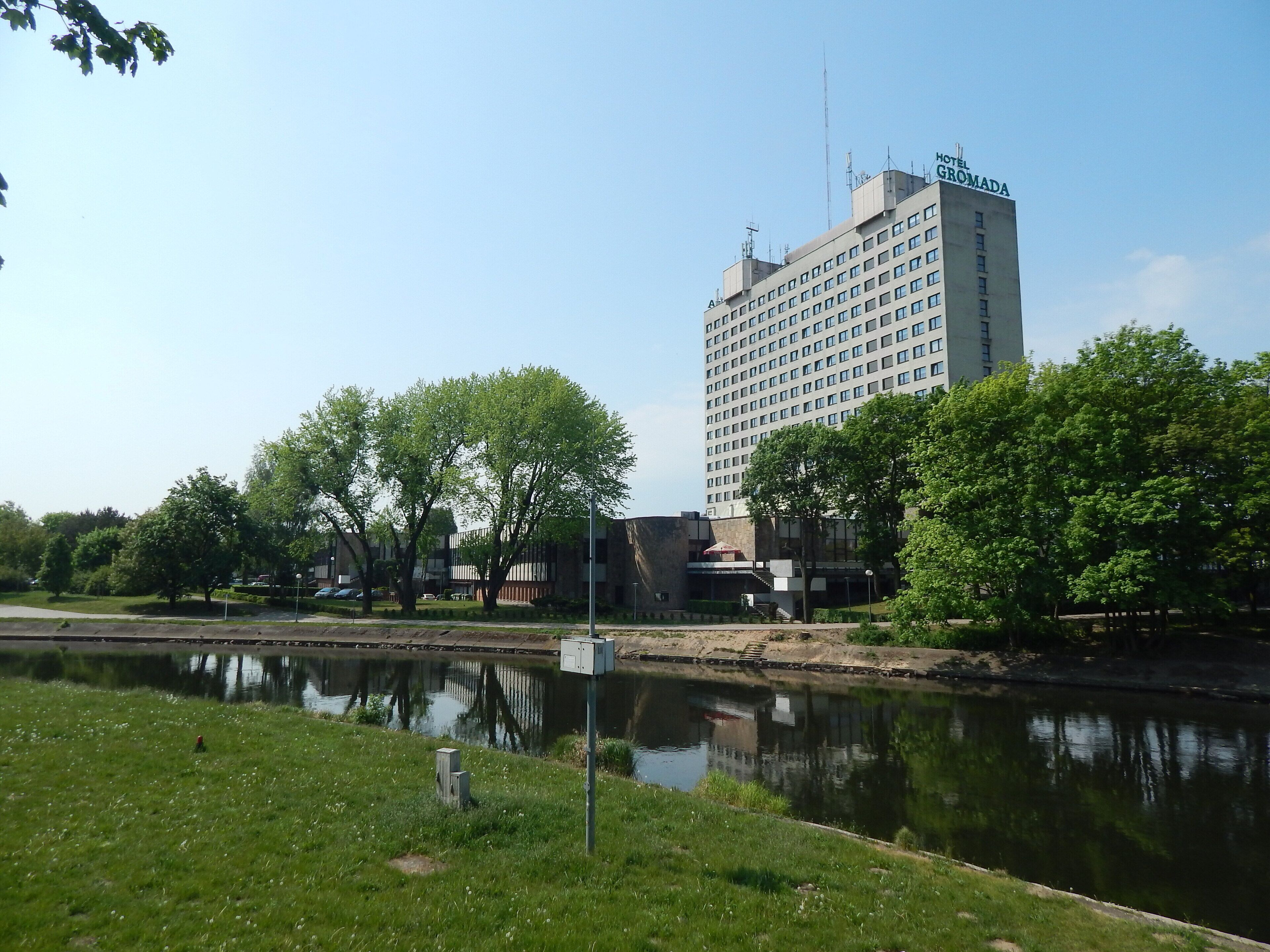 Un hotel de diseño moderno, con un río frente al establecimiento y vegetación circundante.