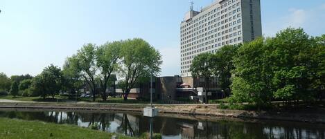 Un hotel de diseño moderno, con un río frente al establecimiento y vegetación circundante.