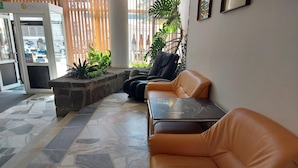 A lobby with a seating area, a reception desk, and a glass door entrance. - Hotel Gromada Zakopane (Zakopane)