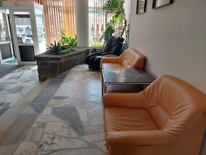 A lobby with a seating area, a reception desk, and a glass door entrance. - Hotel Gromada Zakopane (Zakopane)