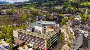 A hotel with a central courtyard, multiple floors, and a mix of modern and traditional architecture. - Hotel Gromada Zakopane (Zakopane)