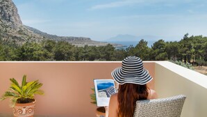 A balcony with a view of a mountainous landscape and a body of water. - Miraluna Hotel (Karpathos)