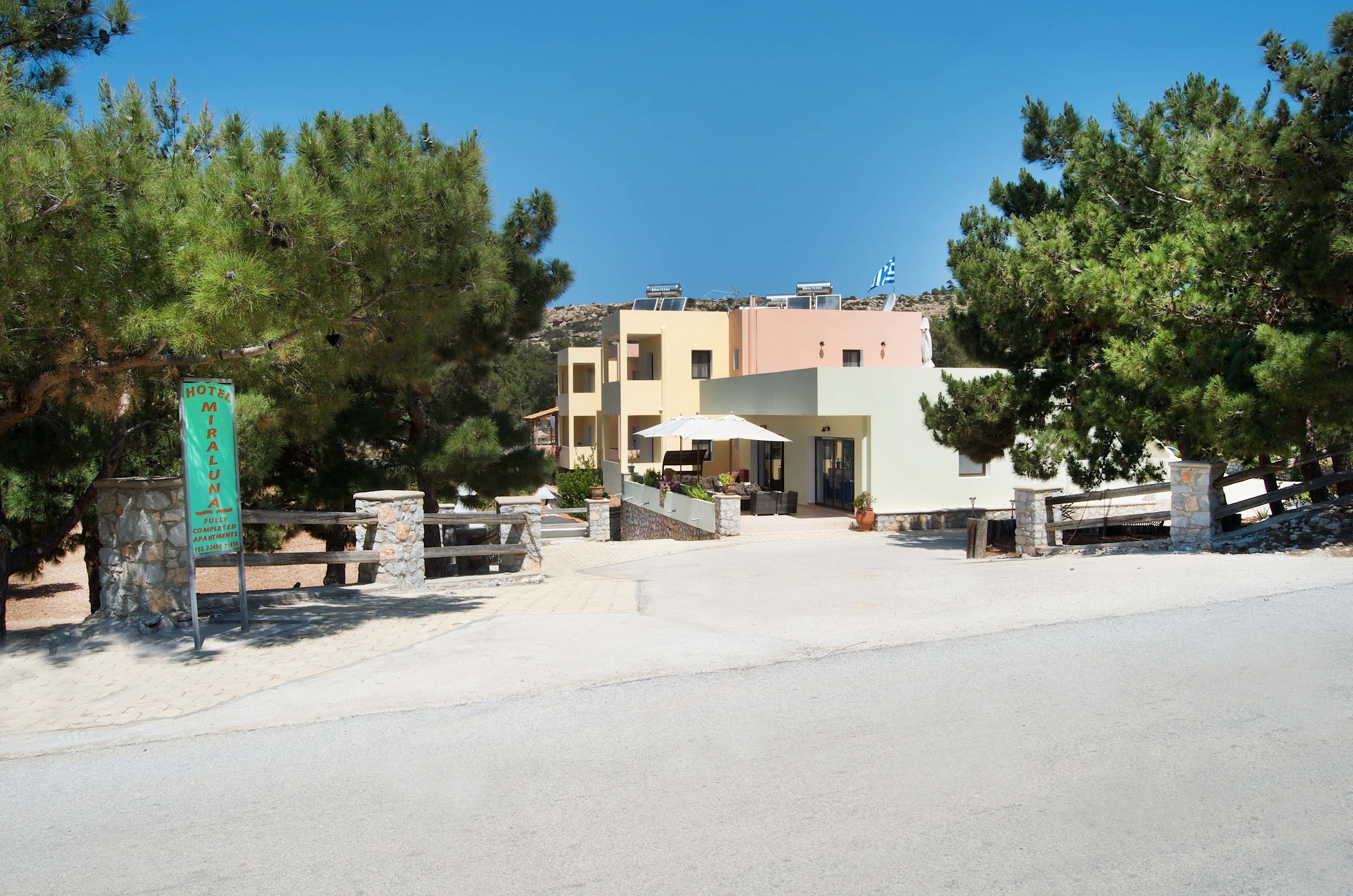 A hotel named 'Hotel Miralon' with a stone entrance, a paved driveway, and a building with multiple balconies.