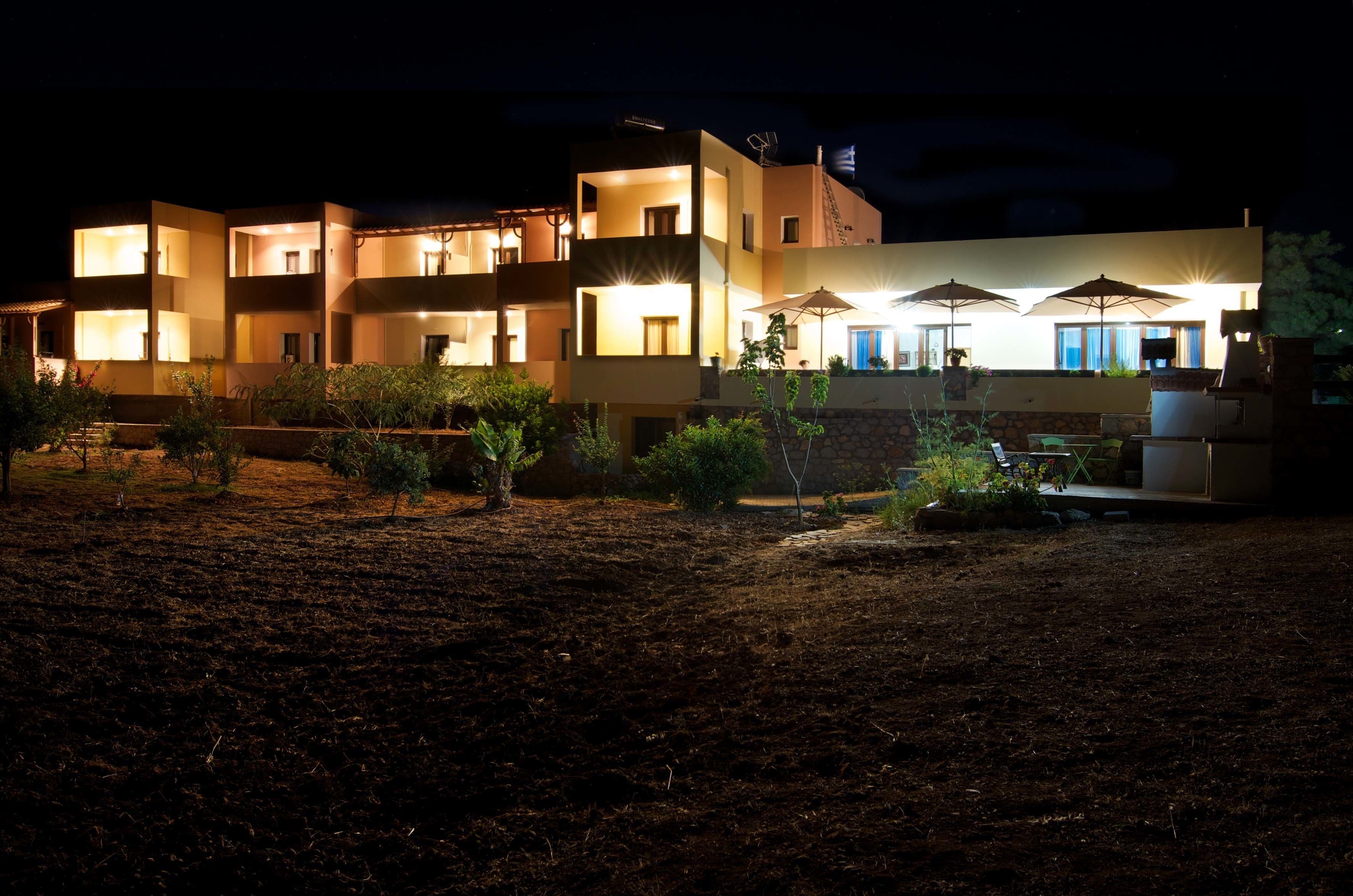 A multi-story hotel with illuminated balconies and outdoor seating areas.