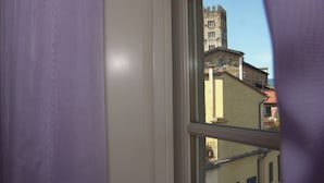 A window view of a building with a tower and a balcony. - Anfiteatro Bed and Breakfast (Lucca)