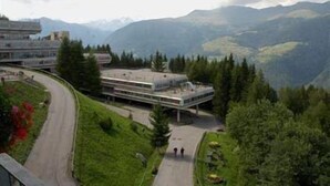A modern building with a flat roof and a long, curved driveway. - Hotel Sole Alto (Mezzana)