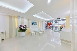 A clean, modern lobby with a reception desk, seating area, and a large potted plant. - Sea Light Hotel (Nha Trang)