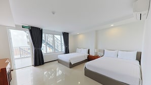Ein Hotelzimmer mit zwei Betten, einem Schreibtisch, einem Stuhl, einem Fenster mit Vorhängen und Blick nach außen.