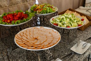 A buffet table with various dishes including sliced meat, salads, and vegetables. - Sea Light Hotel (Nha Trang)