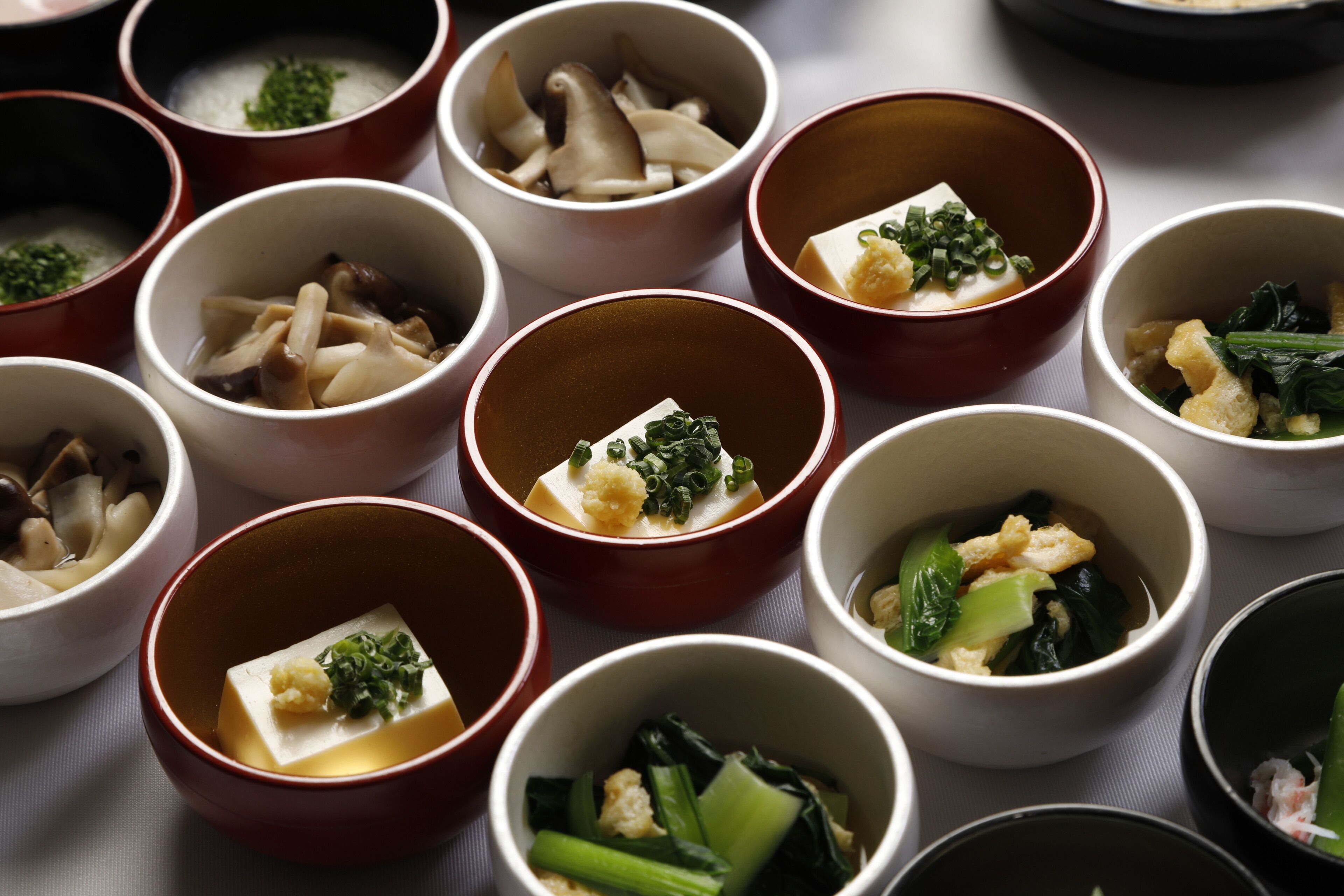 A variety of small bowls containing different types of food, arranged on a table.