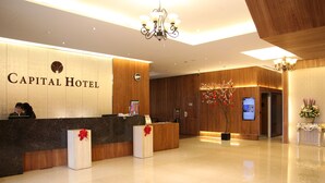 Eine Hotelrezeption mit Marmorzauber, Holzvertäfelung und einer Kristallleuchter.