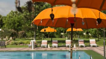 Una piscina techada, una piscina al aire libre de temporada, sombrillas