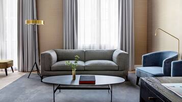 Un salon moderne avec un canapé gris, une table basse ronde et un fauteuil bleu.