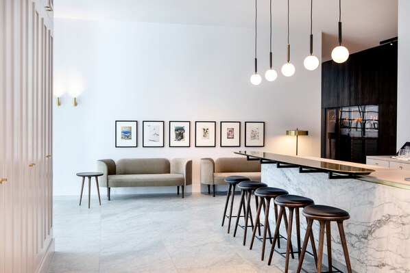 A modern kitchen with a marble countertop, bar stools, and pendant lighting. - Pillows Grand Boutique Hotel Reylof Ghent (Ghent)