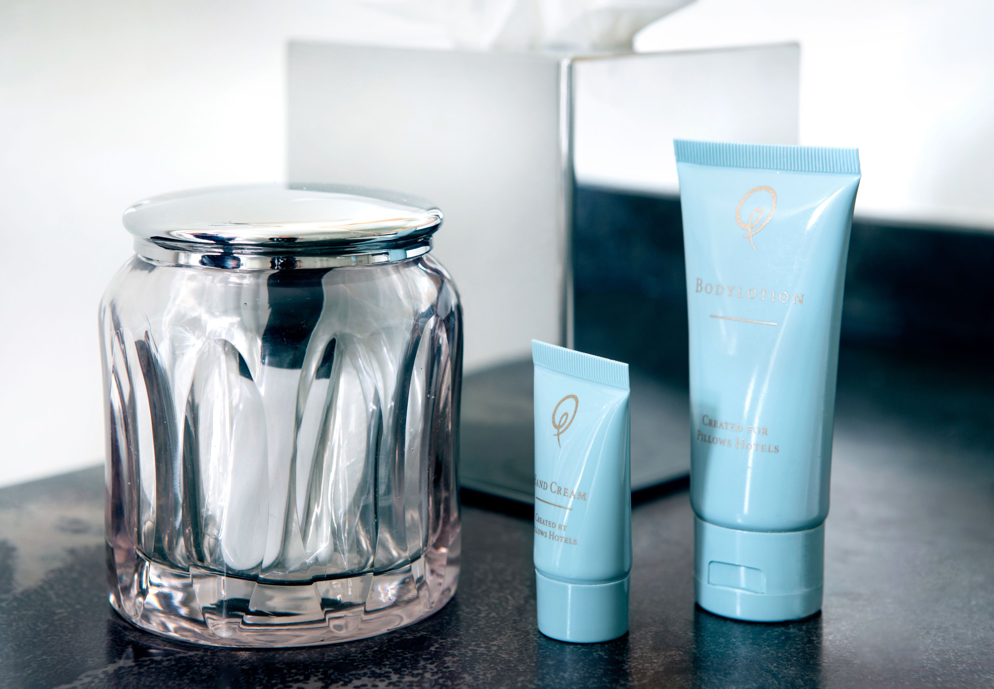 A clear glass jar, a blue tube, and a box on a countertop.