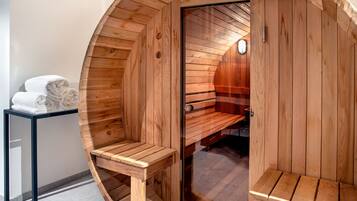 A sauna with wooden walls and benches, a glass door, and a clock on the wall.
