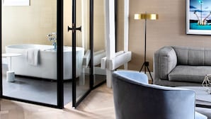 A modern bathroom with a bathtub, a glass shower enclosure, and a large mirror.