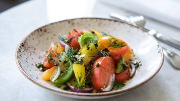 Een kom kleurrijke salade met verschillende groenten en kruiden.