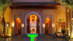 A courtyard with a fountain, palm trees, and a bicycle.