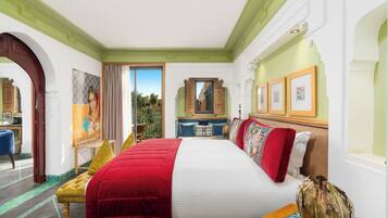 Hotelkamer met een groot bed, een zithoek met een stoel, een klein tafeltje en uitzicht op buiten.