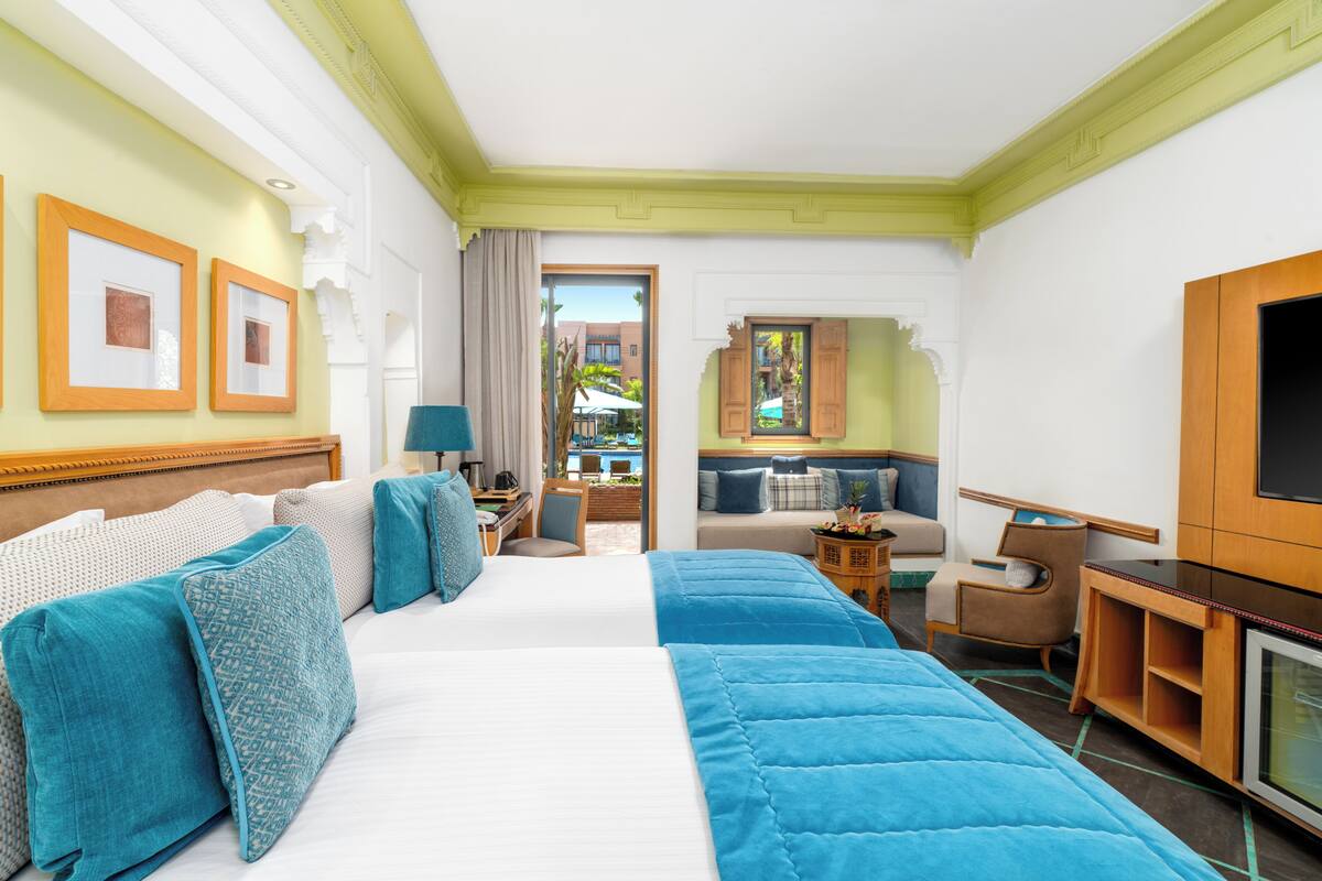 Une chambre d’hôtel avec un grand lit, un bureau, une télévision et une vue sur l’extérieur.