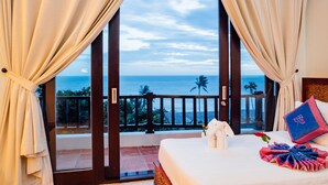 A hotel room with a balcony, a bed, and a view of the ocean. - Lotus Muine Resort & Spa (Phu Thuy)