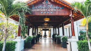 The entrance to Lotus Mune Resort & Spa, featuring a wooden facade, a central entrance, and potted plants on either side. - Lotus Muine Resort & Spa (Phu Thuy)