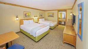 A hotel room with two beds, a desk, a chair, a television, and artwork on the walls. - Grand Country Waterpark Resort (Branson)
