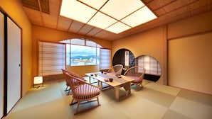 Ein traditioneller japanischer Raum mit Tatami-Böden, einem niedrigen Tisch und Holzsesseln.