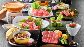 A variety of Japanese dishes including sashimi, vegetables, and a hot pot setup.