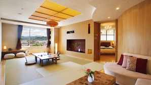Ein modernes Wohnzimmer mit Tatami-Böden, einer Couch, einem Couchtisch und einem Kamin.