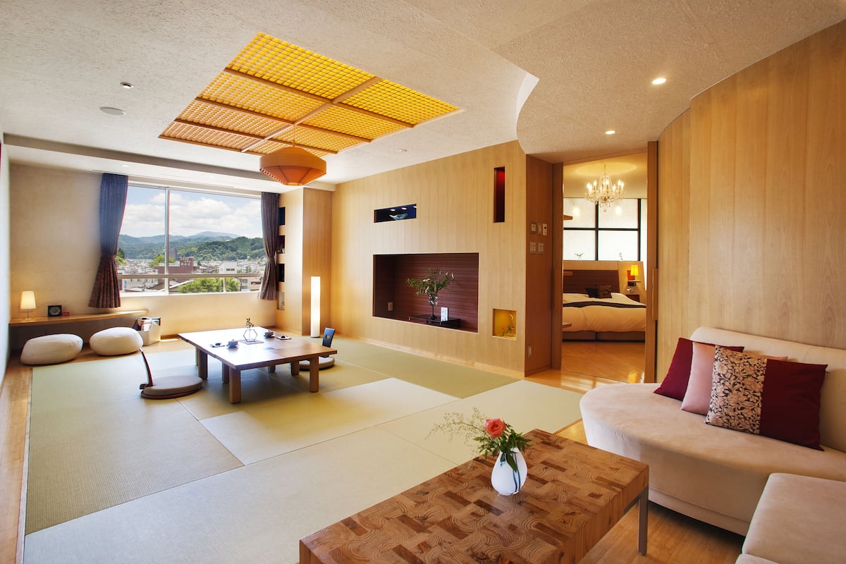 A modern living room with tatami flooring, a sofa, a coffee table, and a fireplace.