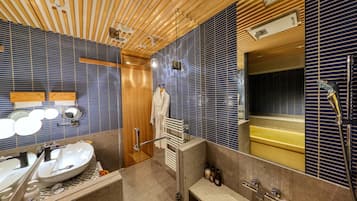 A modern bathroom with a wooden ceiling, a large mirror, a sink, and a bathtub.