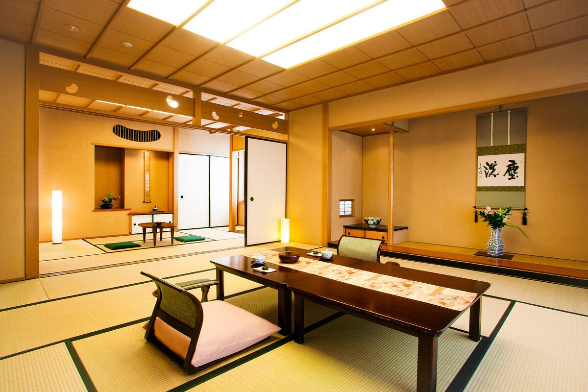A traditional Japanese room with tatami flooring, a low table, and a sliding door.
