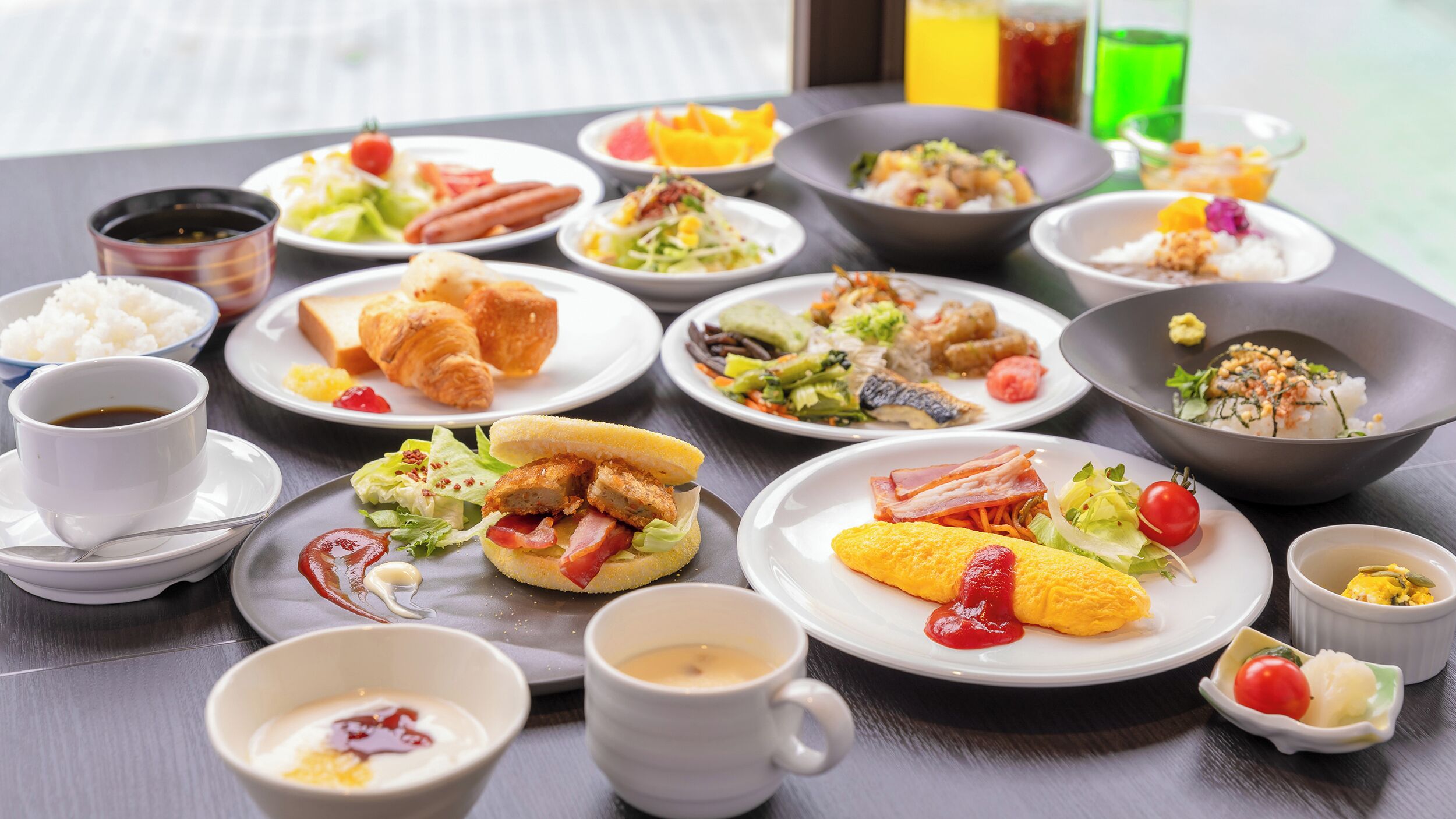 Variedad de platillos que incluyen croissants, ensaladas y tortillas, sugiriendo un ambiente para desayunar.