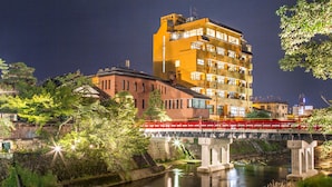 Een meerlaags gebouw met een rode brug over een rivier.