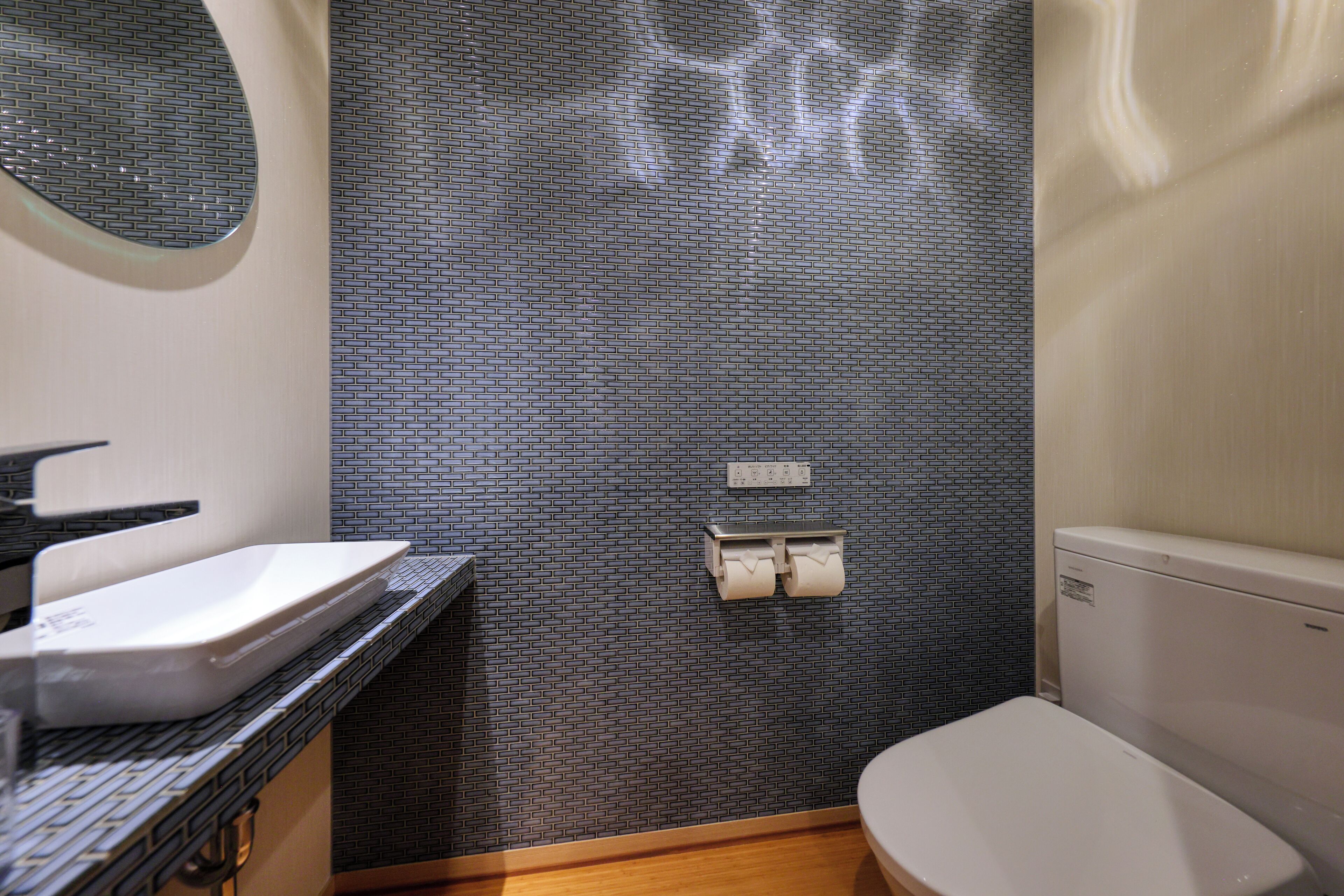A bathroom with a sink, toilet, and a wall-mounted toilet paper holder.