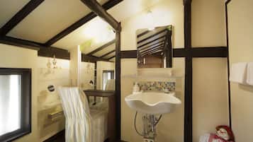 A bathroom with a white sink, a mirror, and a striped chair.